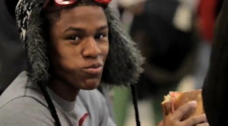 Black man eating a sandwich.